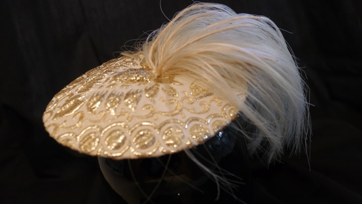 Gold ponytail saucer hat by Nick Savage.